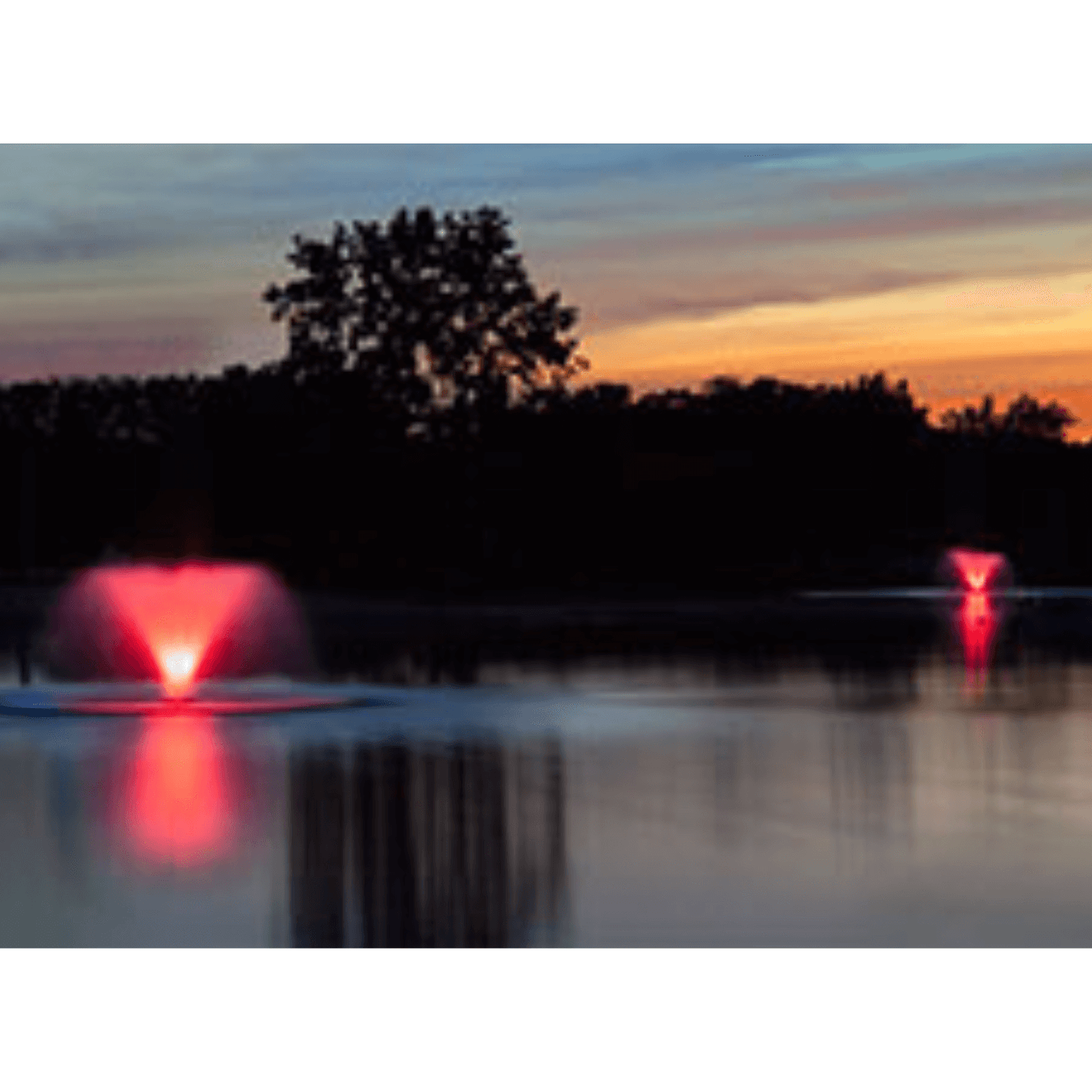 Scott Aerator color-changing RGB fountain lights illuminating a lake fountain at sunset with vivid red LED glow and reflection