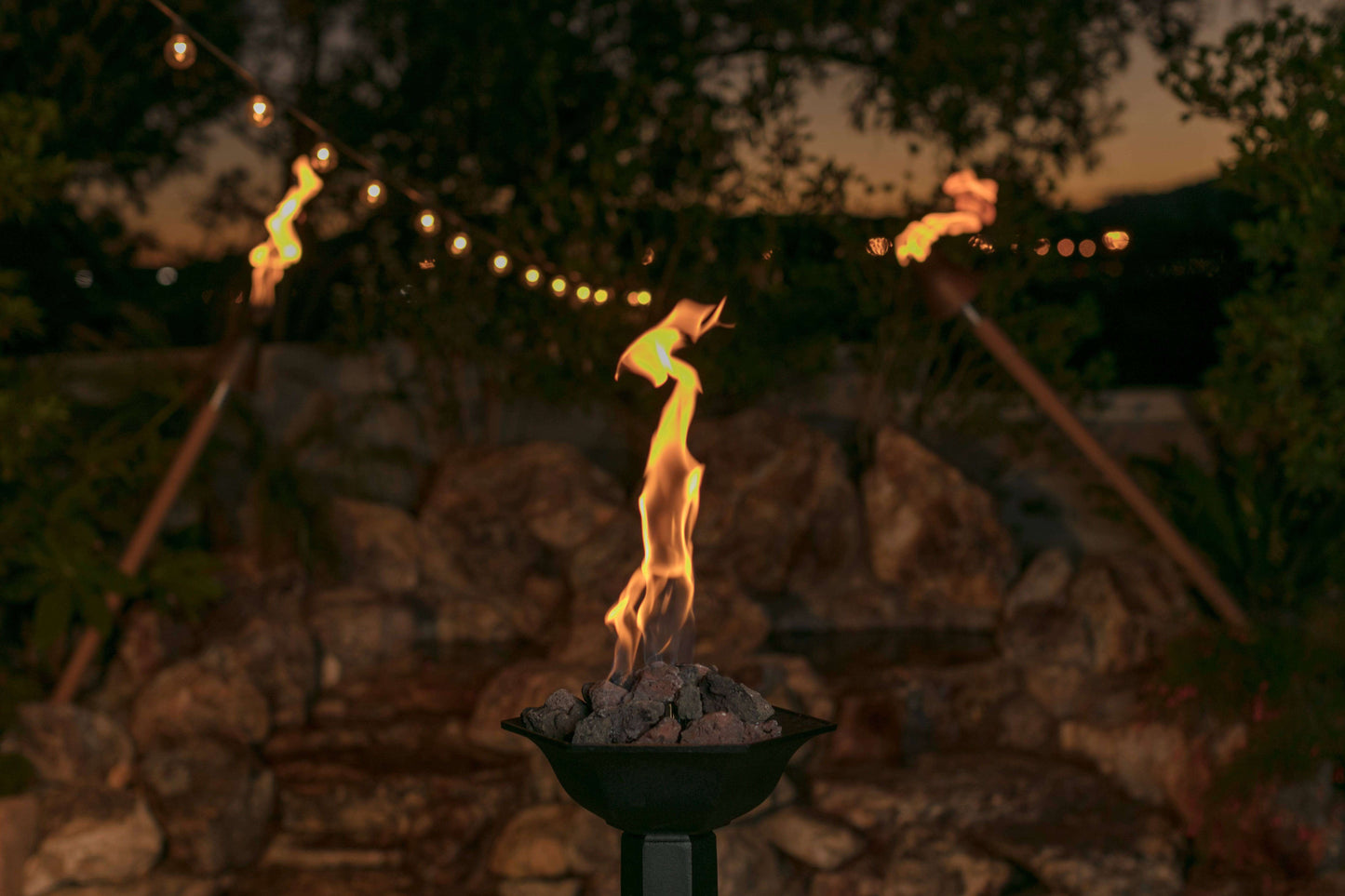 Vulcan Fire Module compact electronic ignition system for fire bowls creating tiki-torch style flame in outdoor fire bowl at dusk