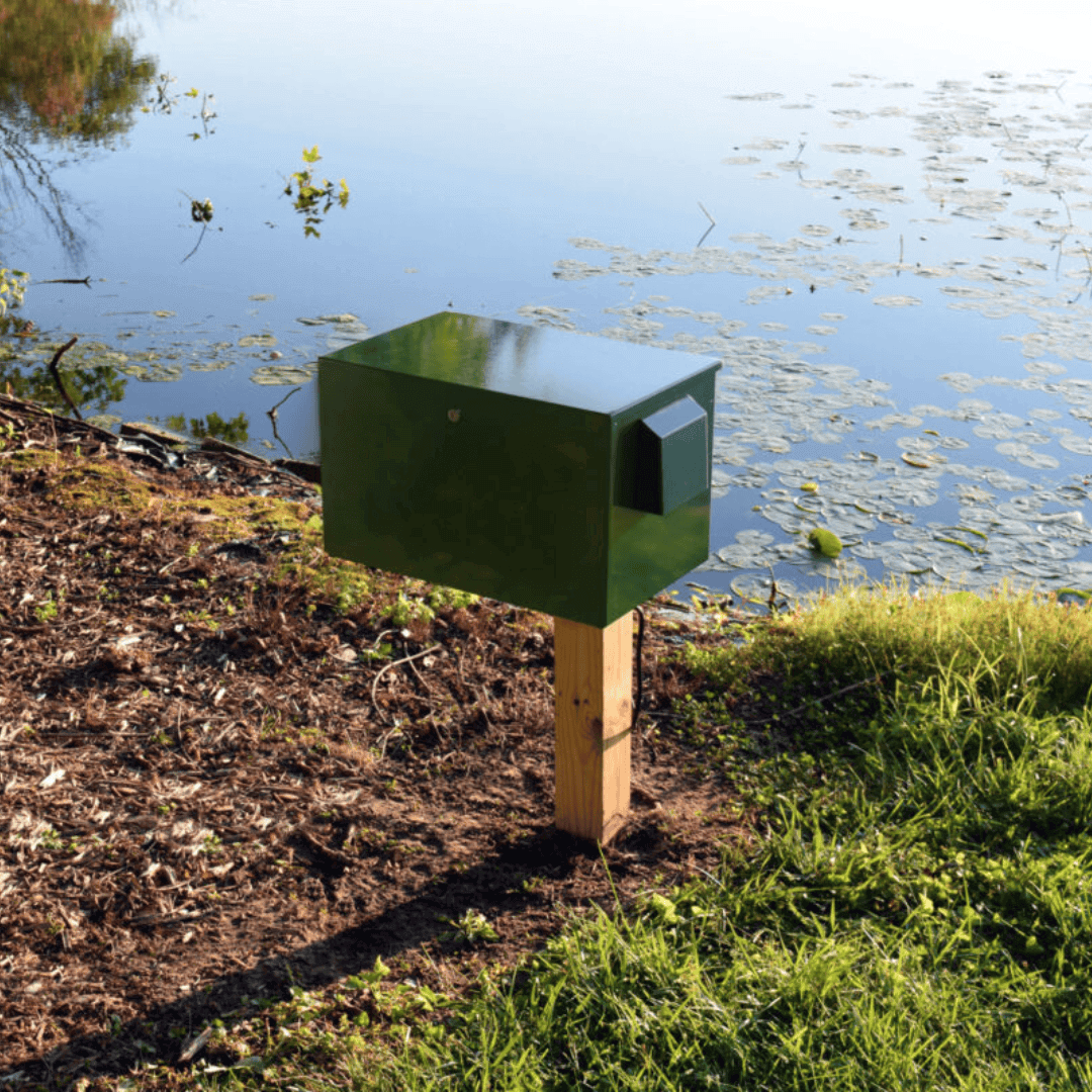AirPro Deluxe pond aerator kit for 2 acre ponds post-mounted green aerator cabinet installed on pond shoreline