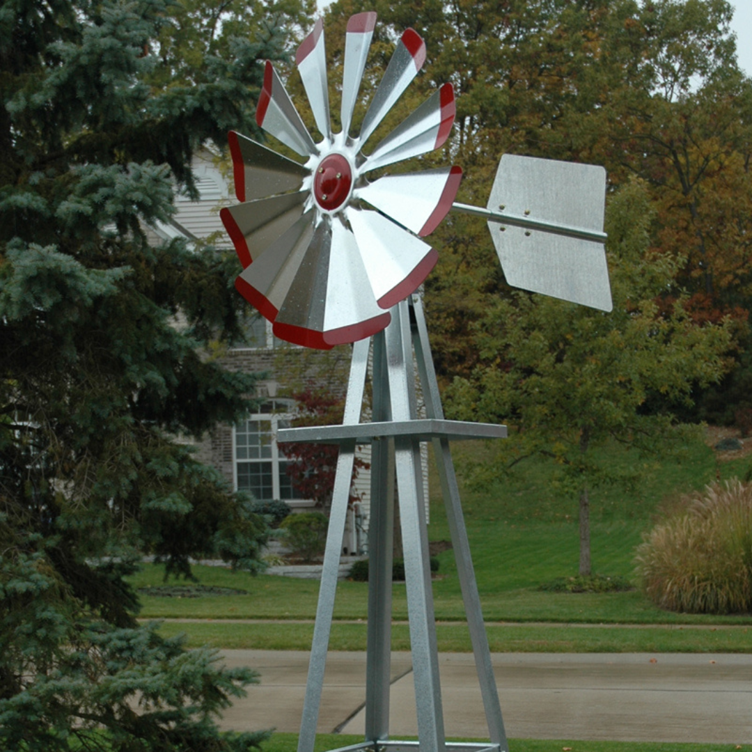 Galvanized Backyard Ornamental Windmill - 8' standing tall in a garden, showcasing its rustic design and durable galvanized steel construction.