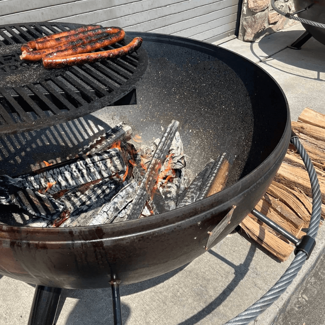 customizable fire pit cooktop grilling sausages over open flame on outdoor fire pit cooktop grate