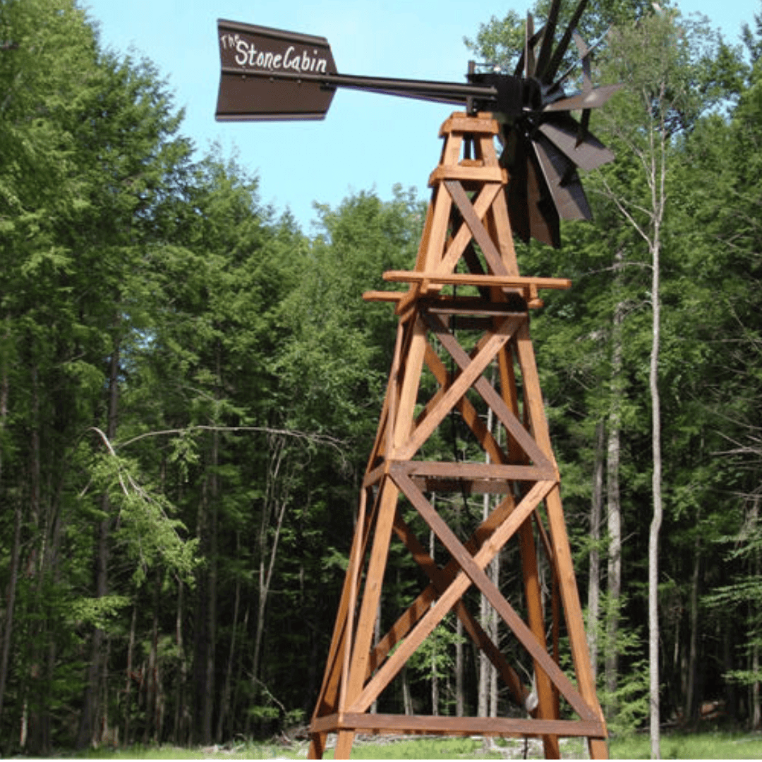 16 ft functional aeration wood windmill 4-legged cedar windmill with vane and blades on lawn near trees