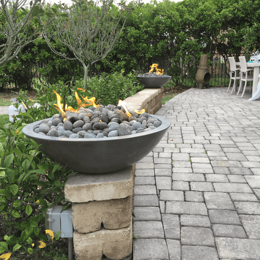 Zen Fire Bowl 32 inch GFRC fire pit bowl on patio wall with lava rocks and flames in outdoor garden setting
