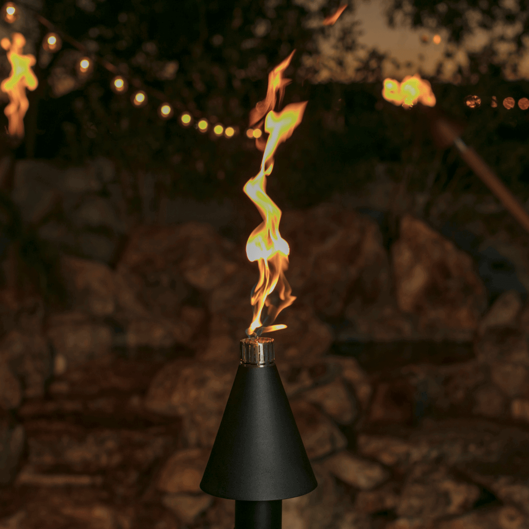 automated black cone tiki torch lit with tall flame, modern outdoor gas torch adding warmth and ambiance at night