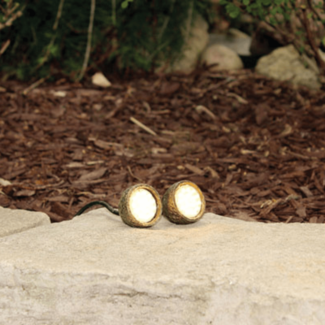 compact underwater mini LED pond lights on stone with warm white glow, rock-style housings for hidden landscape and pond lighting