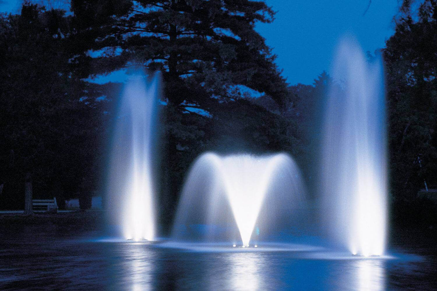 Otterbine Fountain Glo LED low voltage light kit illuminating a lake fountain display at night with bright white water jets