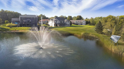 Scott Aerator Solar Amherst pond fountain spraying a three-tier display on a residential pond with two-panel solar power system