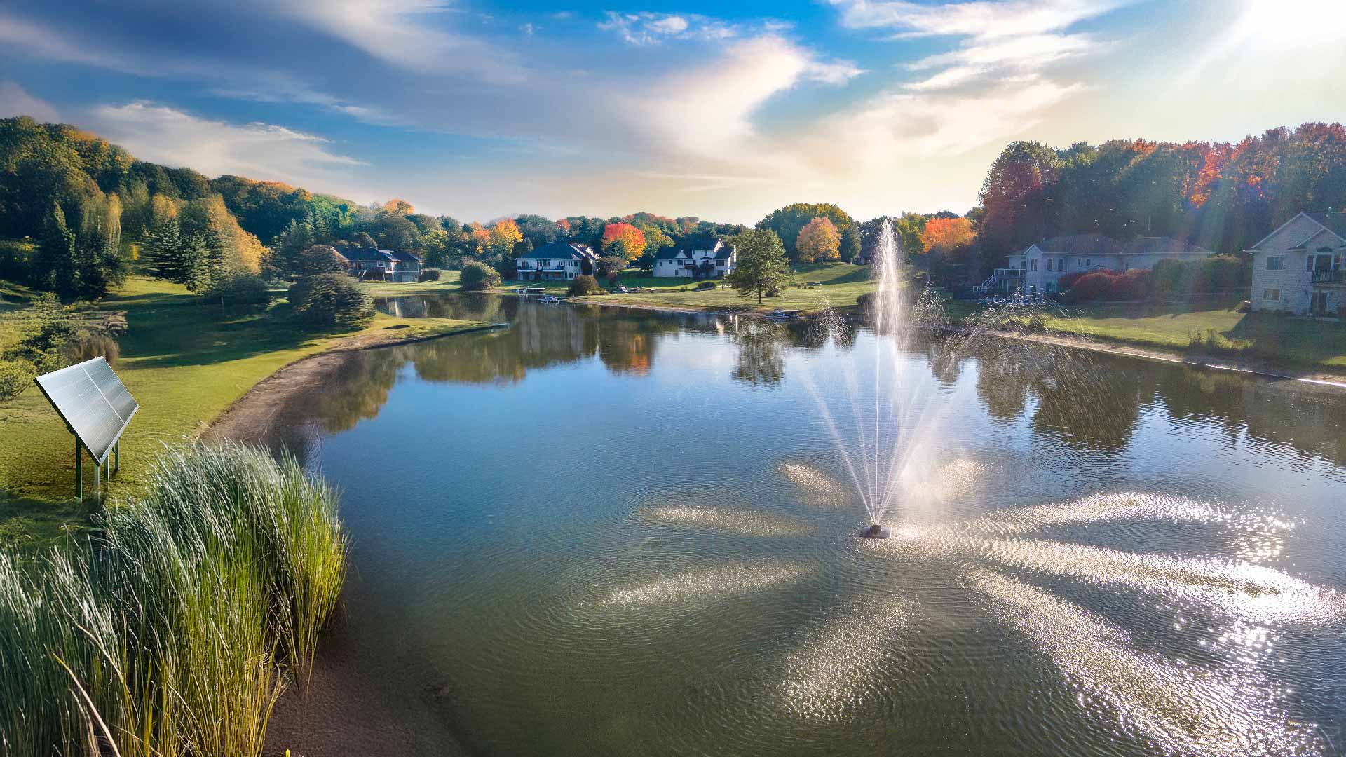 Scott Aerator Solar Atriarch 1/2 HP solar pond fountain spraying 9-jet pattern on lake with two-panel solar power