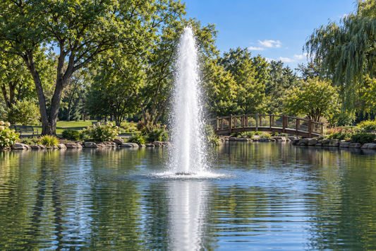 Otterbine Comet floating fountain shooting a tall single column of water in a park pond