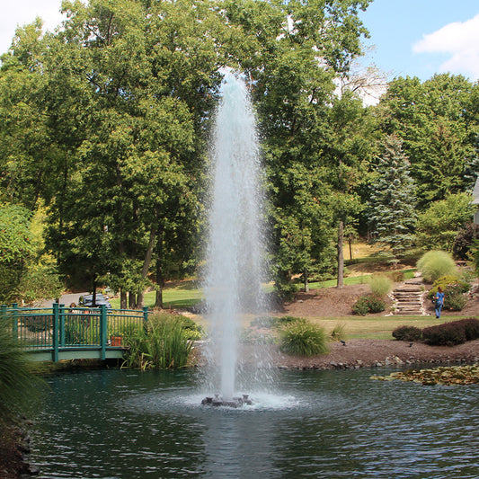 Otterbine Comet floating aerating fountain with tall single-column spray installed on a pond